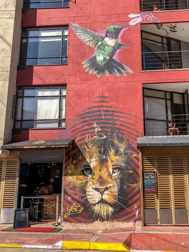 Bogota mural- lion and bird with red background by Franco