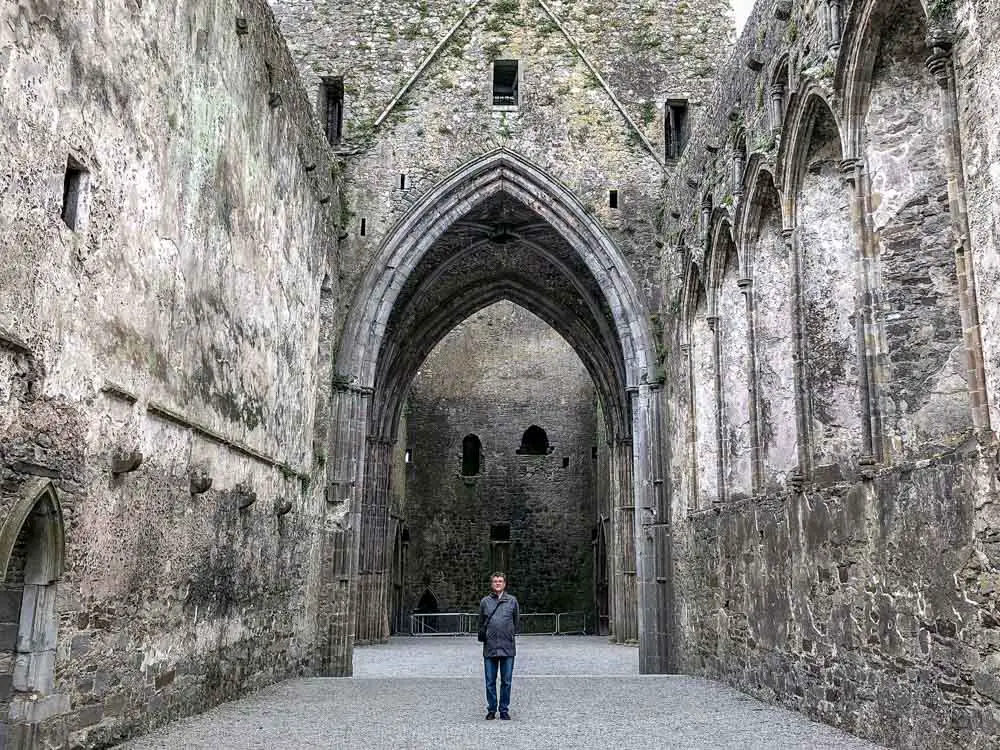 Ireland: Rock of Cashel interior. Man standing in cathedral ruin