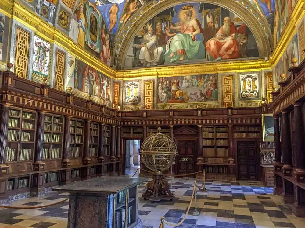 El Escorial library in Spain. Globe sculpture, bookshelves and murals